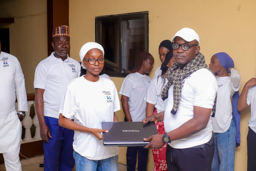 Girl child receiving laptop donation to help with school work